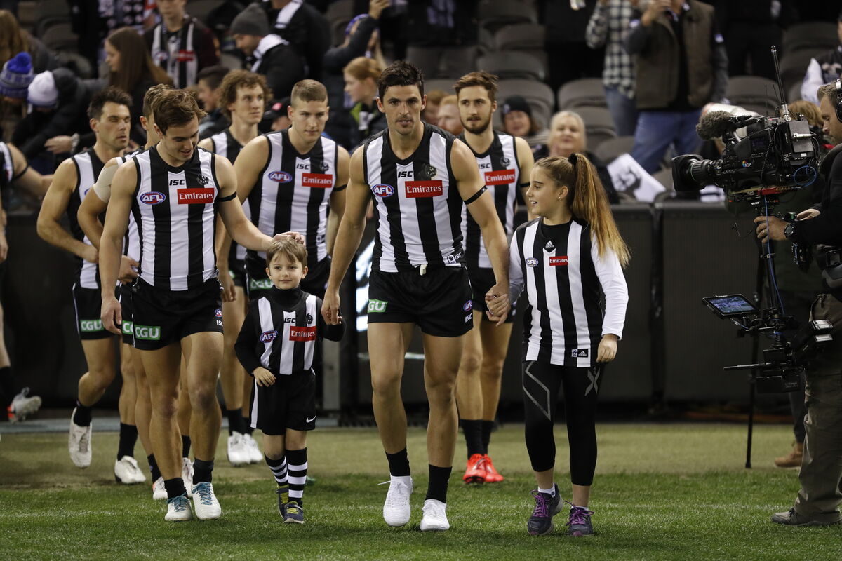 Collingwood AFL team walking on to the field at sports venue